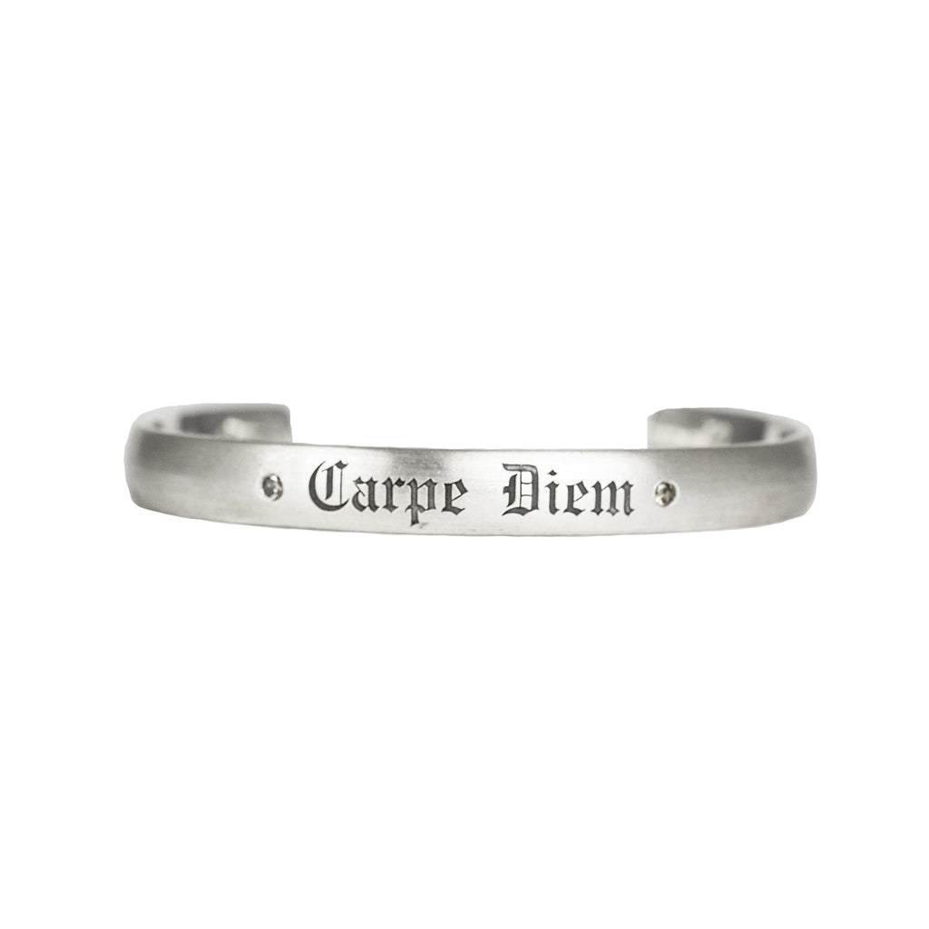 Satin brushed sterling silver cuff bracelet with champagne diamonds next to custom engraving reading "Carpe Diem" in fine Gothic letters