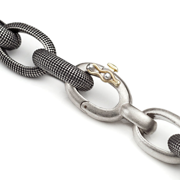 Closeup on safety clasp featuring gold and silver