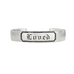 Custom engraveable sterling silver cuff bracelet with black diamond border and engraved message reading "Loved" in fine gothic lettering